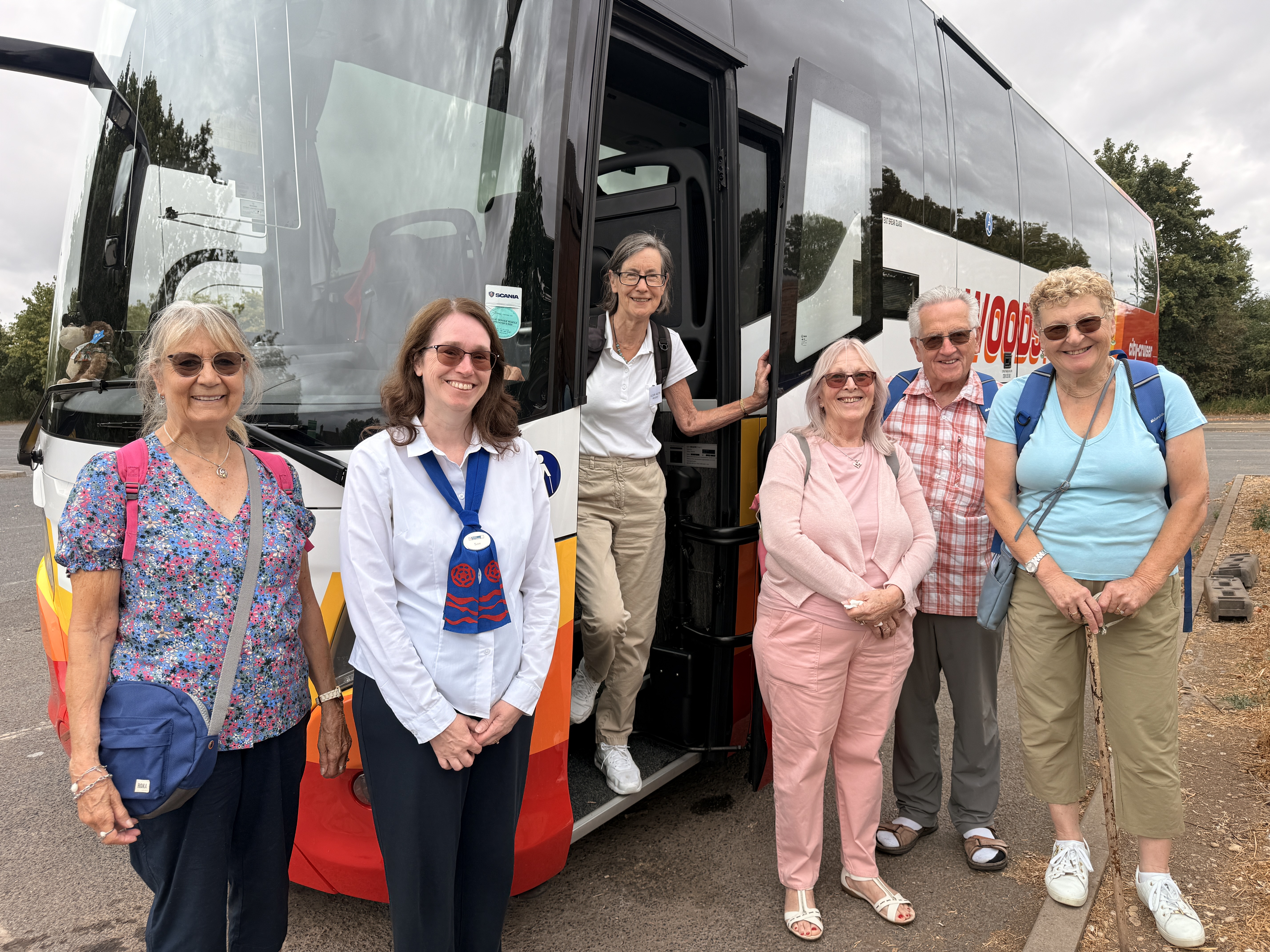 A group of people standing beside a coach