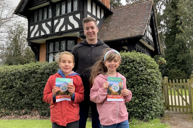 A family are stood at Madresfields holding the ClueQuest posters.
