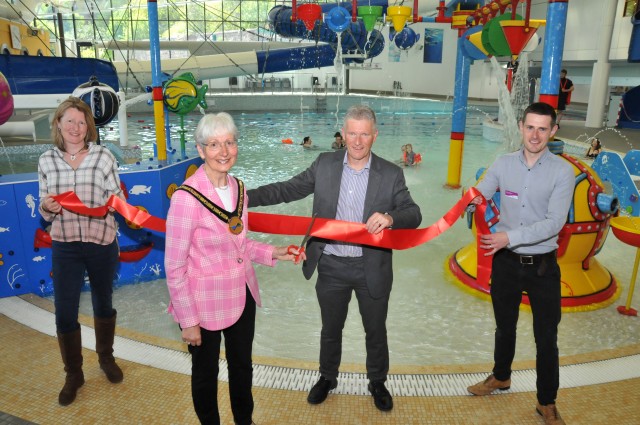 Cllr Sarah Rouse, Leader of Malvern Hills District Council, Ivan Horsfall-Turner, Managing Director of Freedom Leisure, and Nick Charlton, Manager of Malvern Splash holding a red ribbon in front of the Malvern Splash swimming pool while Cllr Cynthia Palmer, Chairman of Malvern Hills District Council cuts it.
