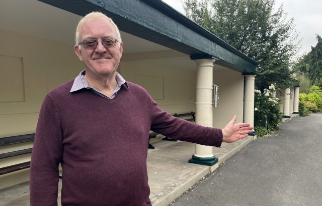 Cllr Peter Whatley standing in front of the newly refurbished shelters in Priory Park