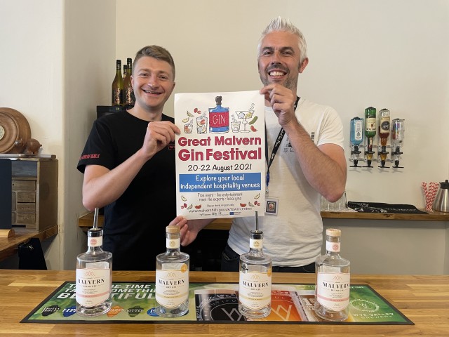 Jeff Parlett, from The Old Con Club and Cllr Daniel Walton, Portfolio Holder for Economy and Tourism on Malvern Hills District Council, standing side by side holding a poster promoting the Great Malvern gin festival.